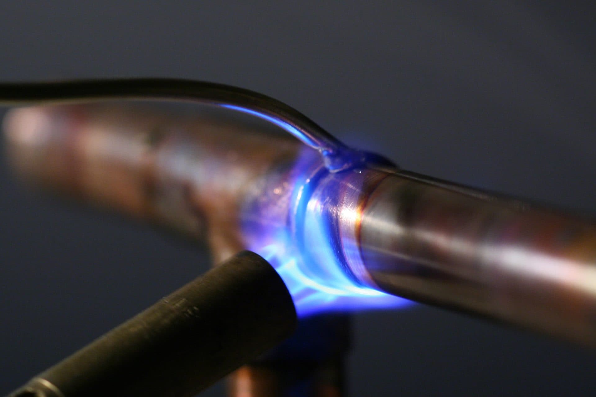 TJ Plumbing tradesman soldering a copper pipe joint with a torch - the actual hero image from the plumbing demo site