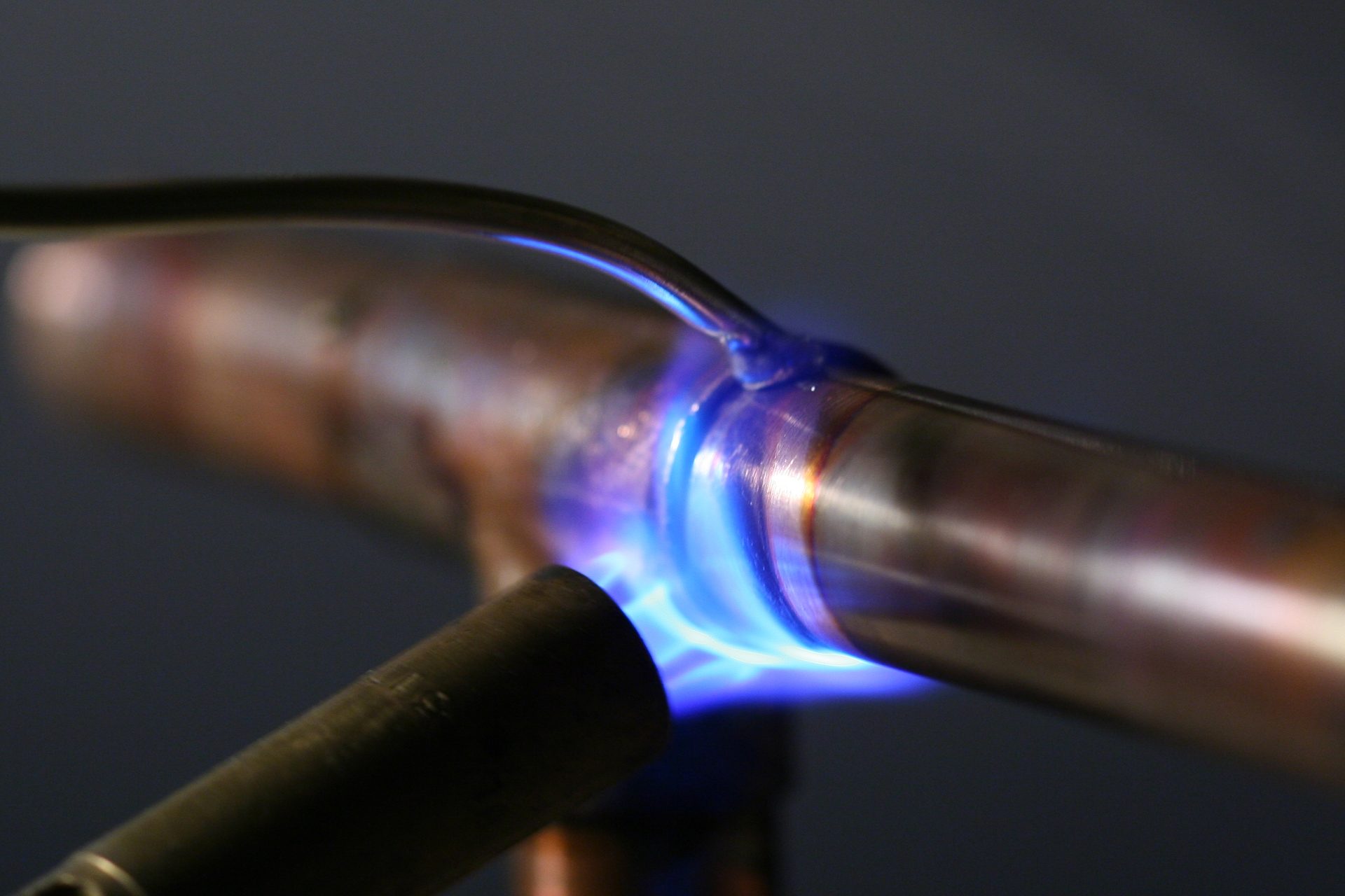TJ Plumbing tradesman soldering a copper pipe joint with a torch