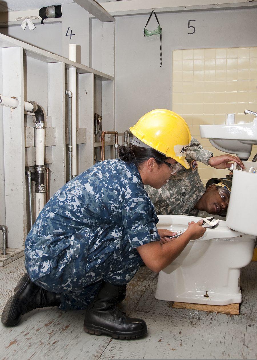 Plumbers installing a toilet during a bathroom renovation