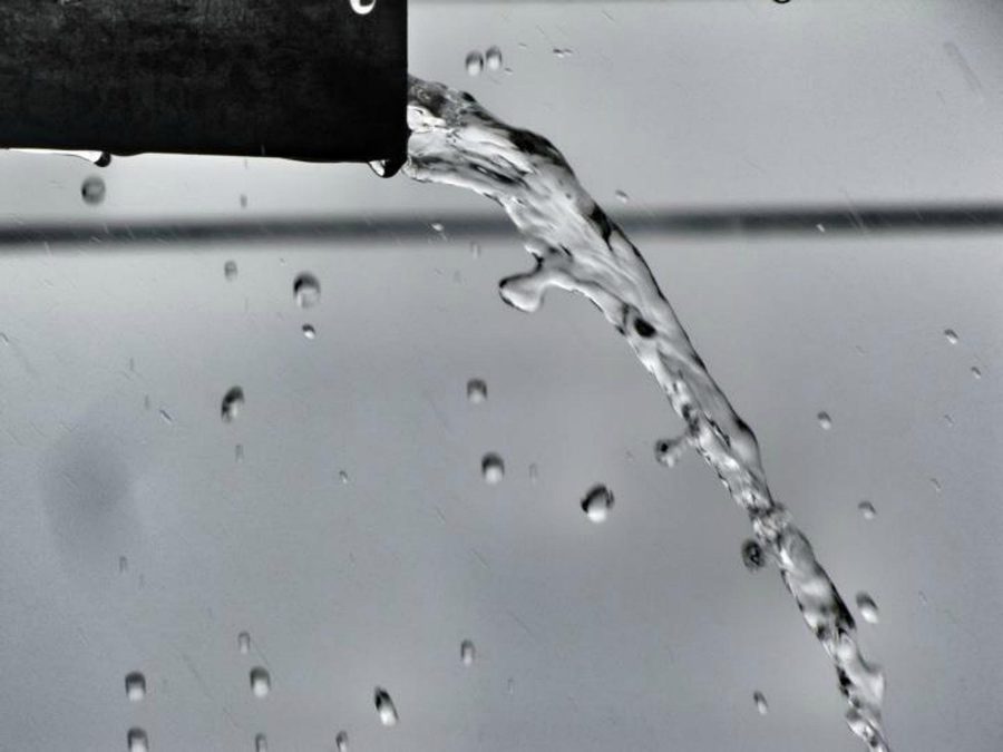 Water pouring urgently from a burst pipe